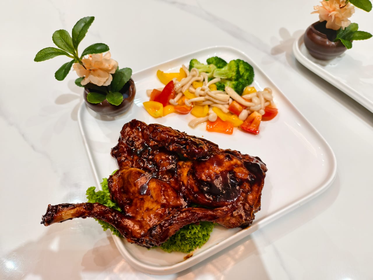 Spanish Duroc pork chop coated in a glossy honey coffee glaze, served with vegetables and mushrooms